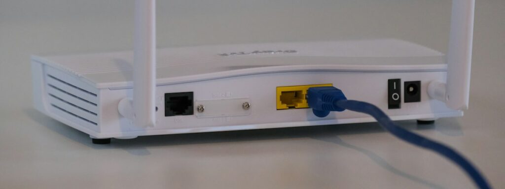 Λευκός δρομολογητής (router) Wi-Fi πάνω σε τραπέζι